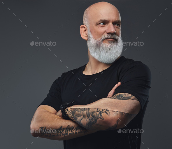Strong elderly sportsman with crossed arms against gray background - Stock Photo - Images
