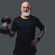 Elderly athlete with dumbell posing against grey background - PhotoDune Item for Sale