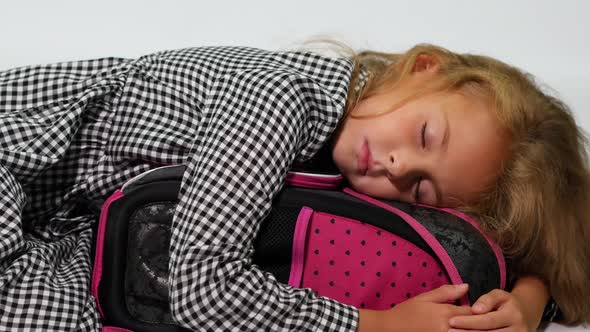 A Student Sleeps Hugging a School Bag alt