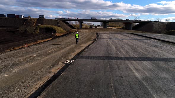 Chief in a White Helmet, Goes and Inspects the Construction of the Road, Aerial Survey alt