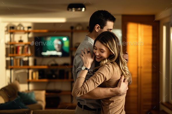 Young affectionate couple dancing at home.
