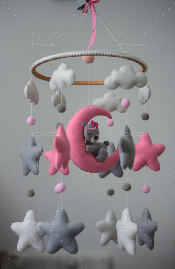Baby cot mobile, musical toy hanging over the baby crib. Dreamy bear in the moon
