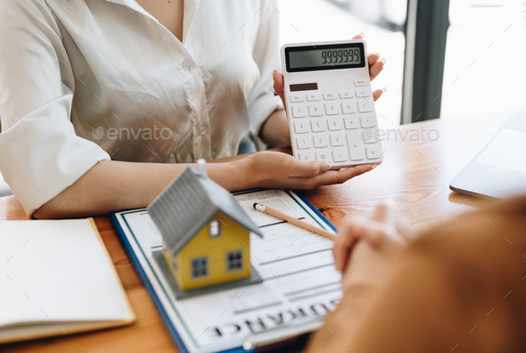 Real estate agent or bank officer describes the loan interest to the customer with home purchase - Stock Photo - Images