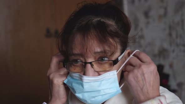 Portrait of Elderly Sad Woman Wearing Protective Mask in Her Room at Home at Quarantine During