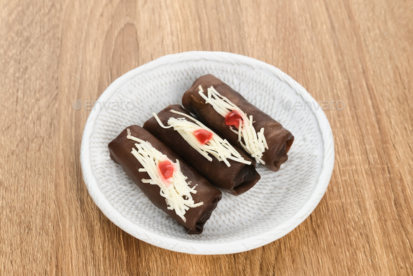Dadar gulung pisang coklat is Indonesian traditional snack Stock Photo