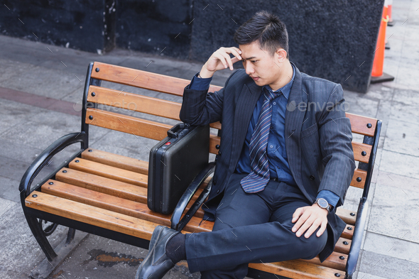 Stressful businessman sitting outdoor