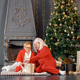 Old woman with her adult daughter sitting near Christmas tree - PhotoDune Item for Sale