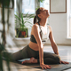 Young fit woman practice yoga doing asana in light yoga studio with green  house plant Stock Photo