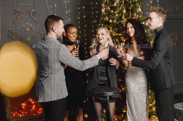 Male and female friends in elegant dresses celebrating New Year - Stock Photo - Images