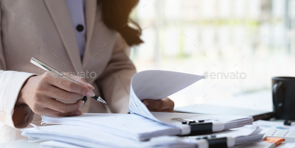 Businesswoman pointing pen at data graph, estimating profit and income statement of business in - Stock Photo - Images