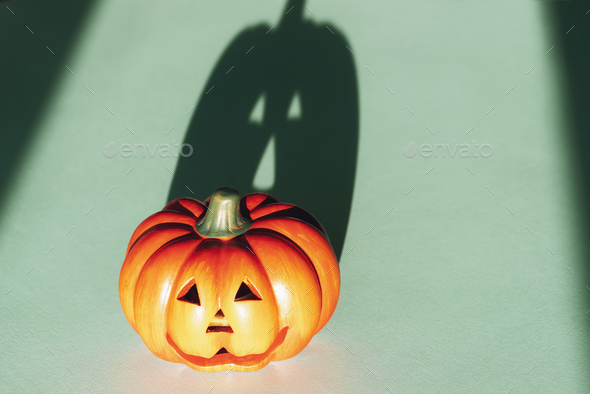 Jack-O-Lantern with strong shadow on blue background. Halloween concept