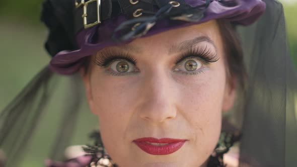 Closeup Witch Face with Long Eyelashes Looking at Camera with Confident Facial Expression alt