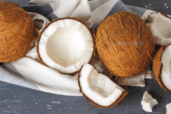 Pile of broken coconuts on ripped grey background - Stock Photo - Images