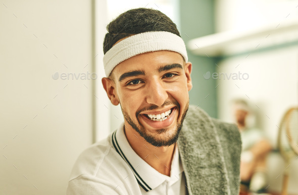 Shot of a young man taking a break in the locker room after a game of squash