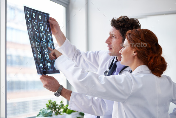 He got lucky this time. Cropped shot of two doctors looking at a brain scan.