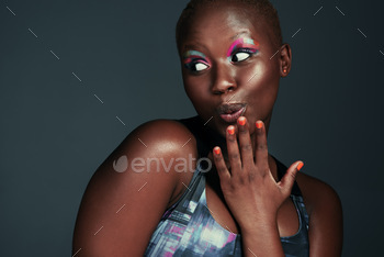 Shot of a beautiful young woman looking surprised while posing against a grey background