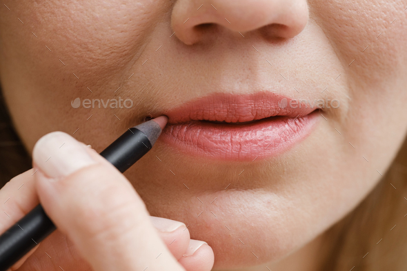 Applying lip makeup, close-up of woman face with