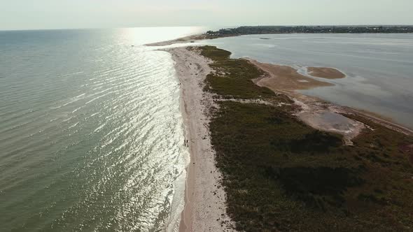 Aerial Shot of a Straight Sandspit Touching a Curvy Line at Sunset in Summer