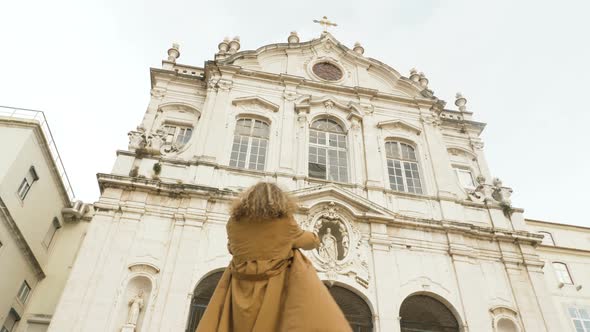 Curly Woman Takes Photos on Smartphone of Ancient Landmark of Lisbon alt