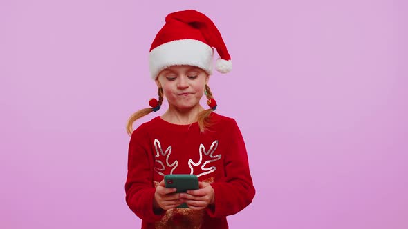 Girl in Christmas Sweater Hat Using Mobile Phone Typing New Post on Web Shopping Online Browsing alt