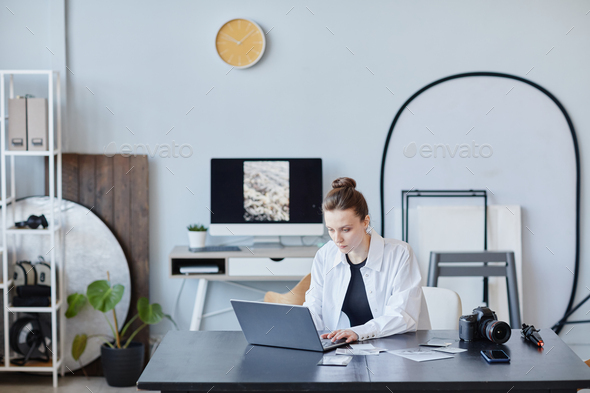 Female Photographer Using Laptop In Studio