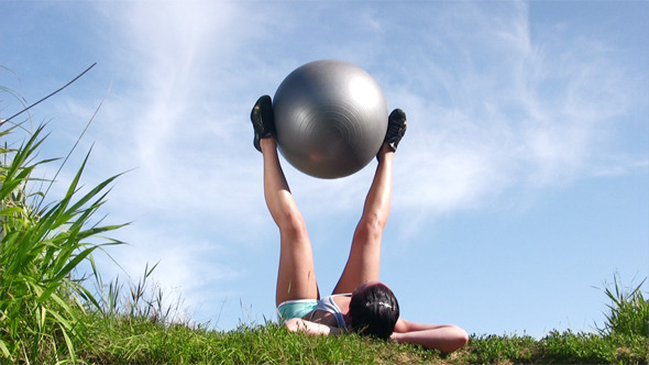 Young Woman Exercising With Ball