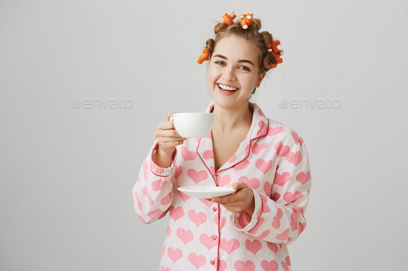 Do you want another cup. Studio portrait of attractive funny woman in hair  curlers making beauty Stock Photo by stock_cookie
