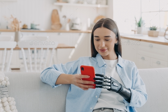 Disabled girl with bionic prosthetic arm holds smartphone. Disability, bionic prosthesis advertising