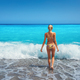 Beautiful young woman in yellow bikini standing in blue sea - PhotoDune Item for Sale