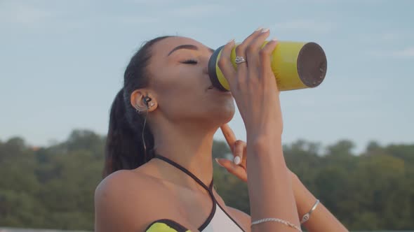 Black Sportswoman Drinking Water After Morning Jog alt