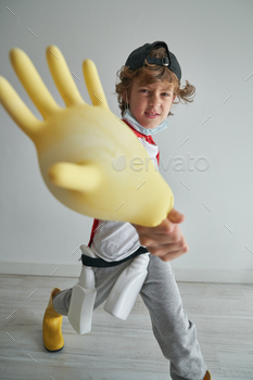 Funny child playing with inflated household glove