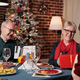 Family exchanging christmas gifts at festive table, having dinner - PhotoDune Item for Sale