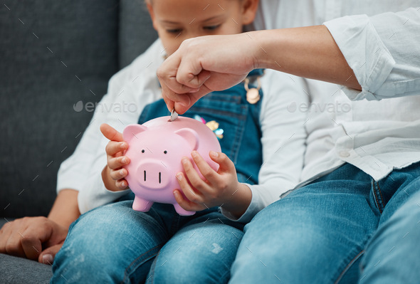 Teaching them to invest young. Shot of a father teaching his daughter to save in a piggybank.
