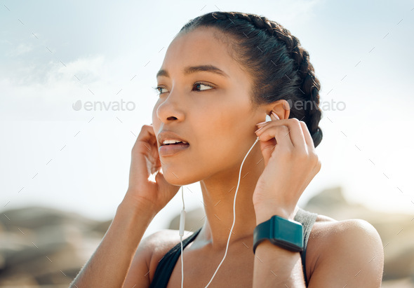 Motivation comes in different forms. Shot of a young woman listening to music during a workout.