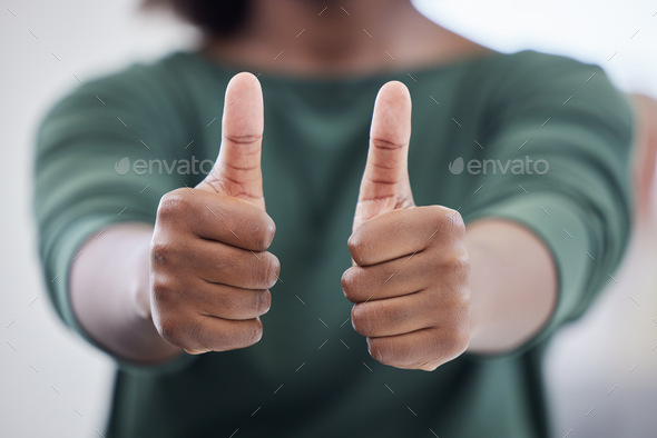 Love it, keep it up. Shot of an unrecognisable businesswoman showing thumbs in a modern office.