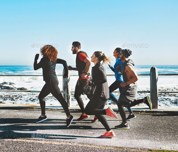 Were all working towards a common goal. Shot of a fitness group out running on the promenade.