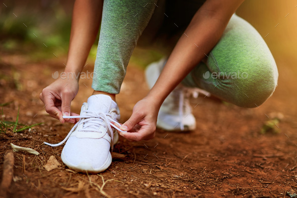 Put your best foot forth. Shot of a sporty young woman tying her shoelaces before a run.