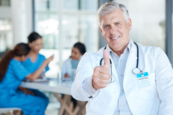 Ready to always give my best. Shot of a mature male doctor during a meeting giving the thumbs up.