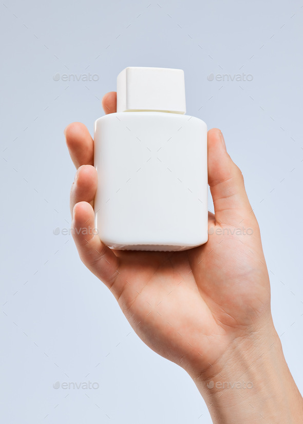 The long lasting factor. Shot of an unrecognizable man holding a bottle against a white background.