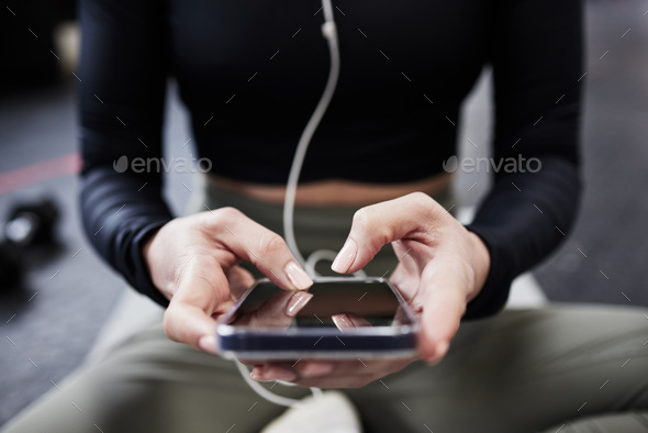 Download the app. Cropped shot of a woman using her cellphone. - Stock Photo - Images