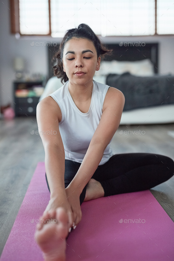 Taking control of her health and wellbeing. Shot of an attractive young woman working out at home.