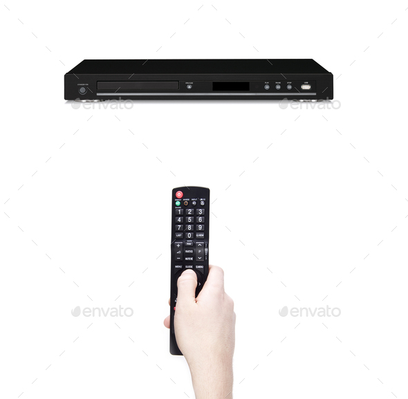 Remote control in the hand against dvd - Stock Photo - Images