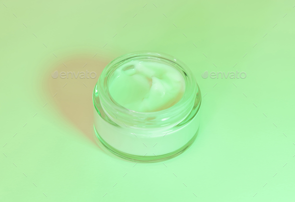 Opened Cosmetic jar close up, mockup. Green light. Everyday skincare routine