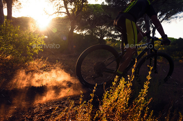 cyclist at full speed on mountain bike at sunset
