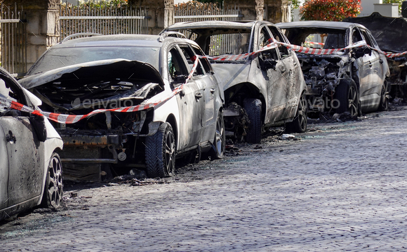 burnt out car wrecks in residential street after vandalism in Germany