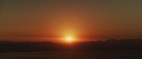 Beautiful landscape with sunset over the big lake and the mountains. Tilting down to up shot.  alt