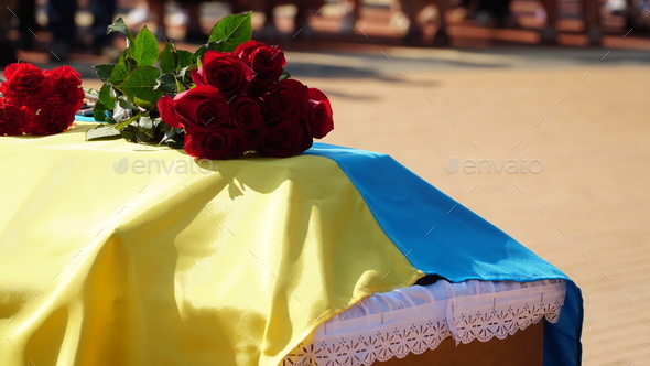 Funeral urn with the ashes of the deceased and flowers at the funeral. people mourning at a memorial