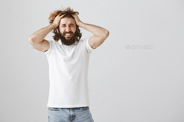 Guy loses temper from bad luck. Portrait of miserable and depressed young eastern man with beard