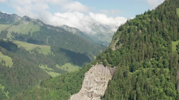 Aerial of beautiful green mountainscape and revealing a stunning Swiss valley alt