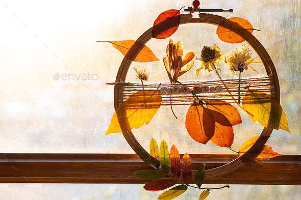 DIY door wreath from autumn colourful leaves and flowers. Fall home decor.